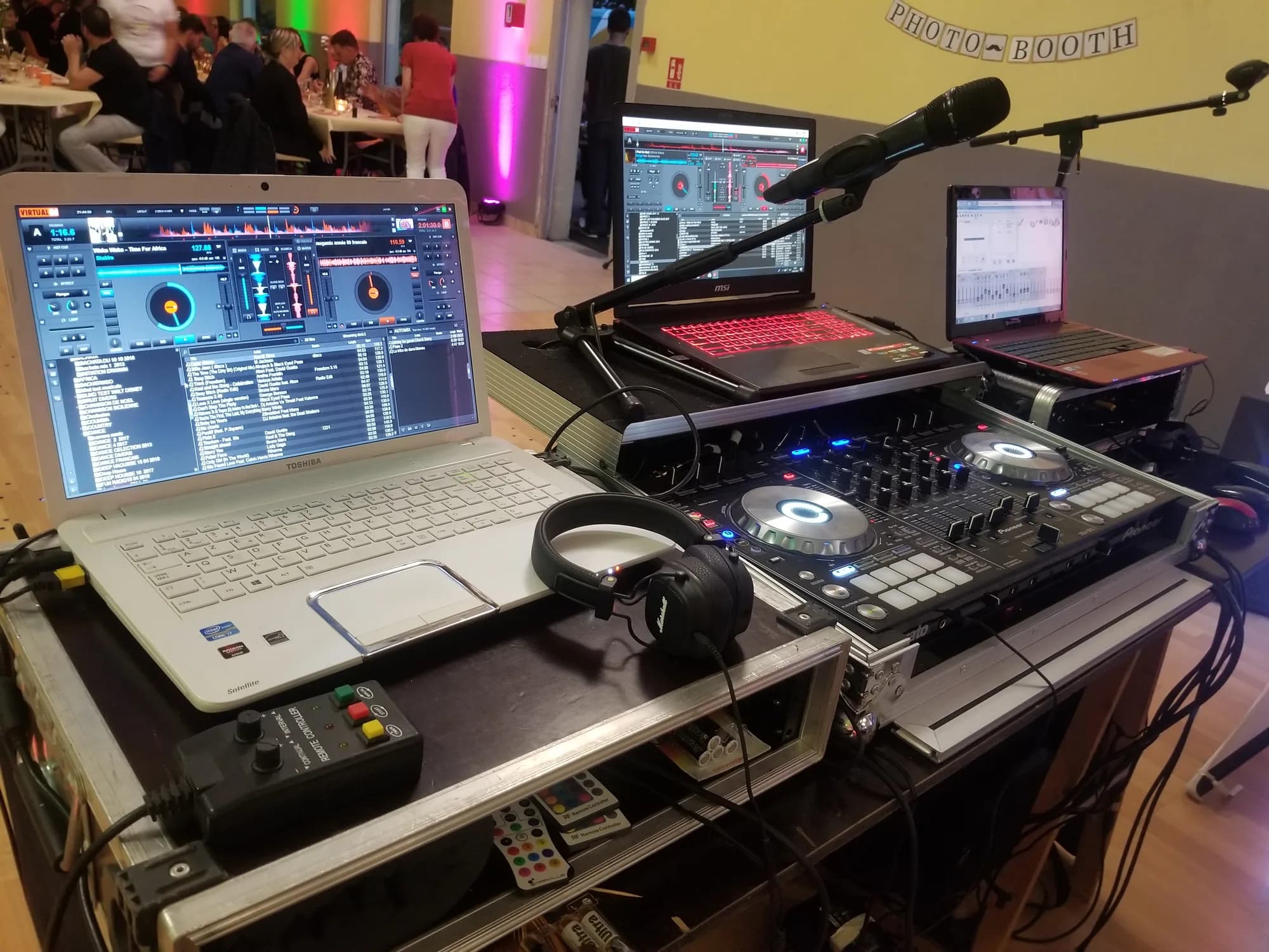 Régie DJ avec contrôleur Pioneer, ordinateur portable, casque et micro sur perche, sous une banderole Photo Booth